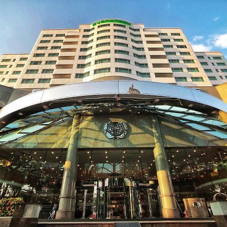 Evergreen Laurel Hotel - Taichung Esterno foto The photo shows the exterior of a modern hotel building. The entrance features a large, glass canopy supported by columns, creating a welcoming area. The facade of the hotel is composed of a mix of glass and concrete, with large windows that suggest 