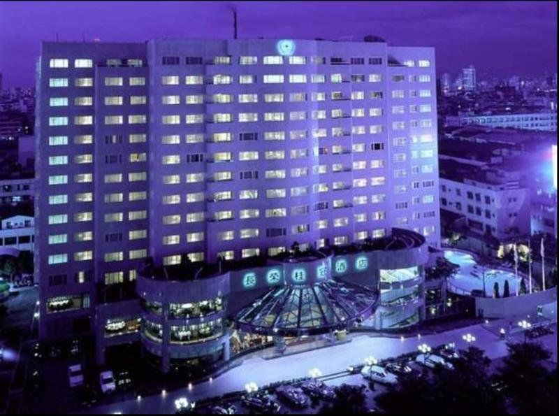 Evergreen Laurel Hotel - Taichung Esterno foto The photo shows a large hotel building illuminated in a purple hue during the evening or nighttime. The facade features numerous windows, many of which are lit, suggesting occupancy. The entrance area appears modern and curved, with a design that inc