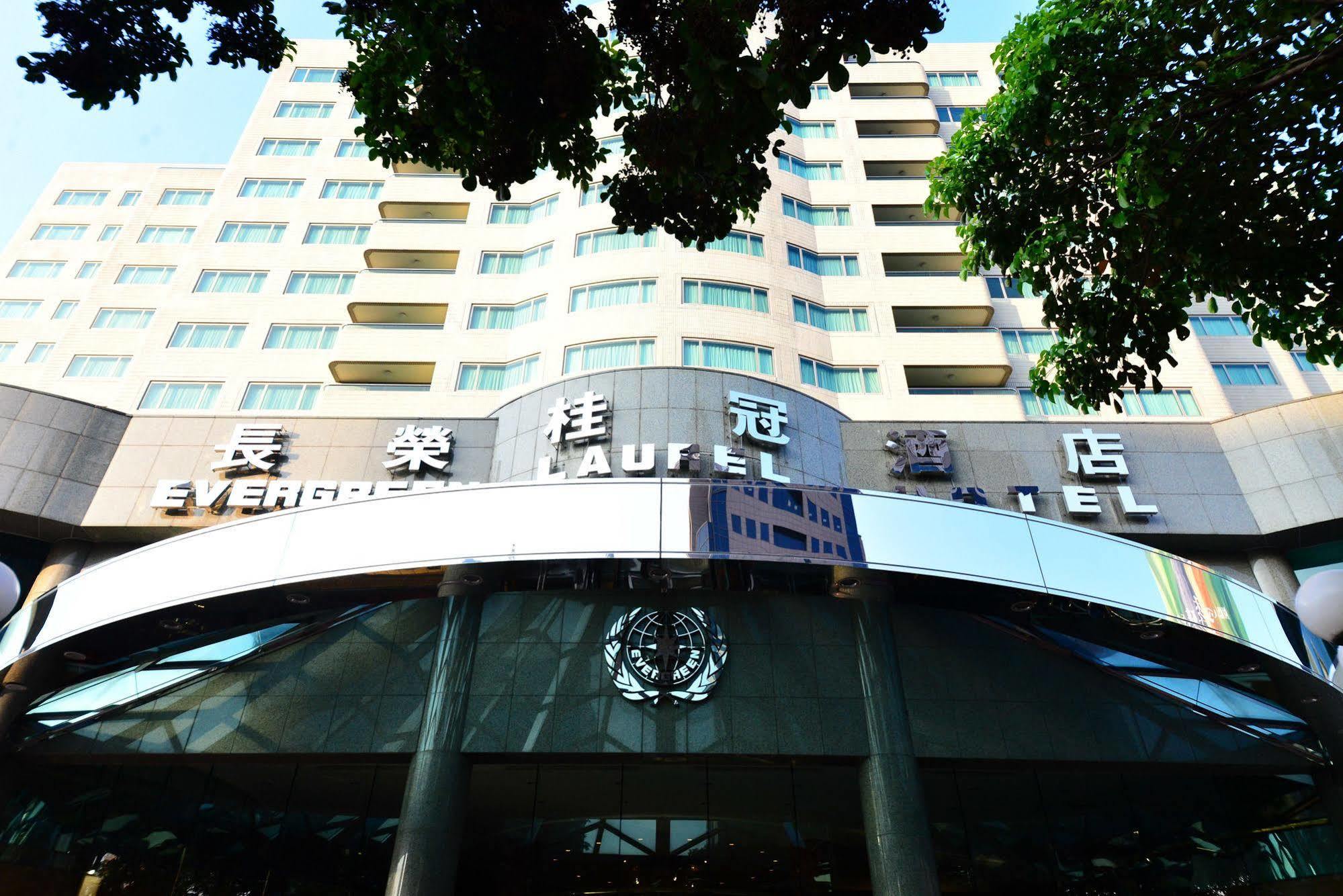 Evergreen Laurel Hotel - Taichung Esterno foto The photo shows the facade of a hotel building, prominently featuring the name "Evergreen Laurel Hotel" displayed in large, visible lettering. The structure is modern with multiple floors, and large windows that suggest a spacious interior. The entra