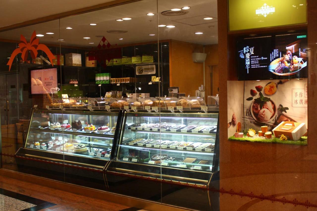 Evergreen Laurel Hotel - Taichung Esterno foto The photo shows a display case in a bakery or dessert shop. The glass case is filled with a variety of pastries, cakes, and desserts arranged neatly. Behind the display, there is a counter with additional items and desserts visible. The walls are dec