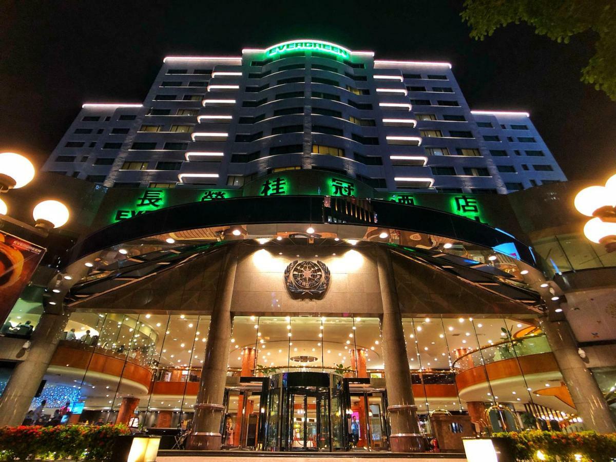 Evergreen Laurel Hotel - Taichung Esterno foto The photo shows a modern building at night, featuring a grand entrance with illuminated signage. The structure has multiple stories with a sleek design, adorned with green lighting that highlights its architectural features. The entrance is spacious 