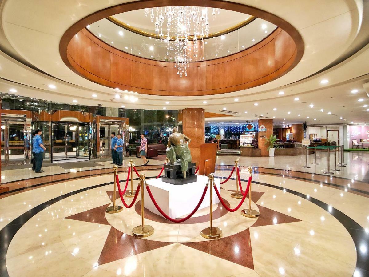 Evergreen Laurel Hotel - Taichung Esterno foto The image shows a spacious lobby area of a building, likely a hotel or an upscale establishment. The design features a circular ceiling with a chandelier hanging from it, creating a bright and elegant ambiance. At the center, there is a statue, likel