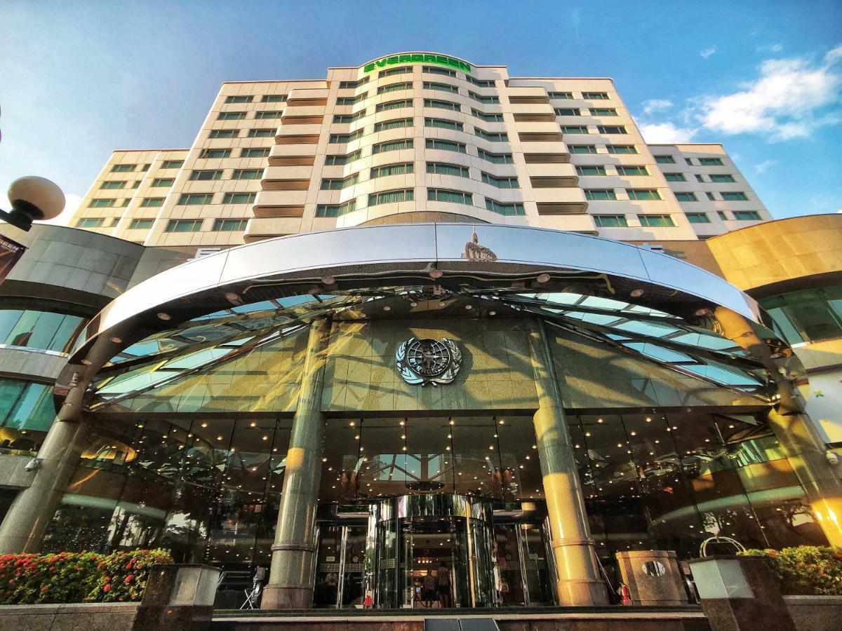 Evergreen Laurel Hotel - Taichung Esterno foto The photo shows the exterior of a modern hotel building. The entrance features a large, glass canopy supported by columns, creating a welcoming area. The facade of the hotel is composed of a mix of glass and concrete, with large windows that suggest 