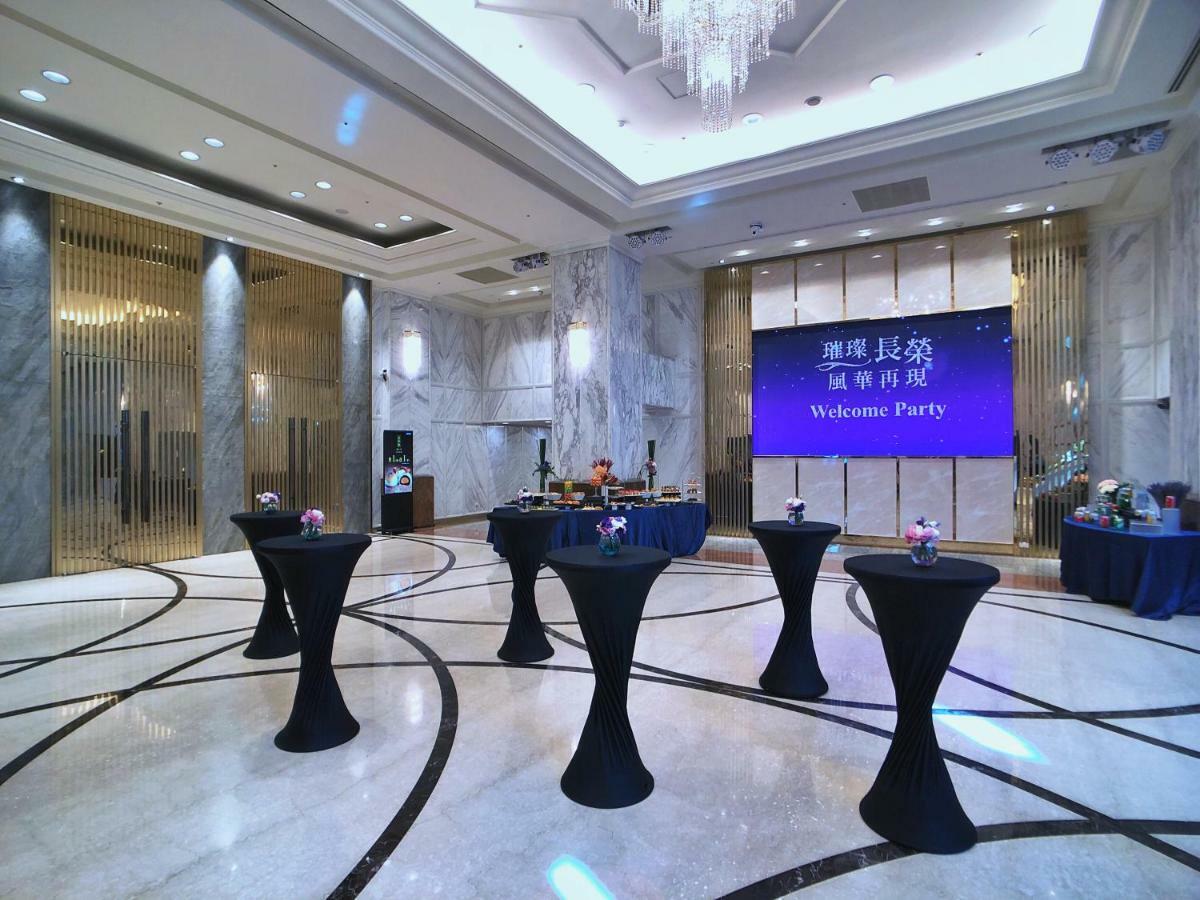 Evergreen Laurel Hotel - Taichung Esterno foto The photo depicts a spacious and elegantly decorated event space, likely set up for a welcome party. The room features polished marble flooring and tall ceilings, giving it a sophisticated atmosphere. In the center, several round tables with black ta
