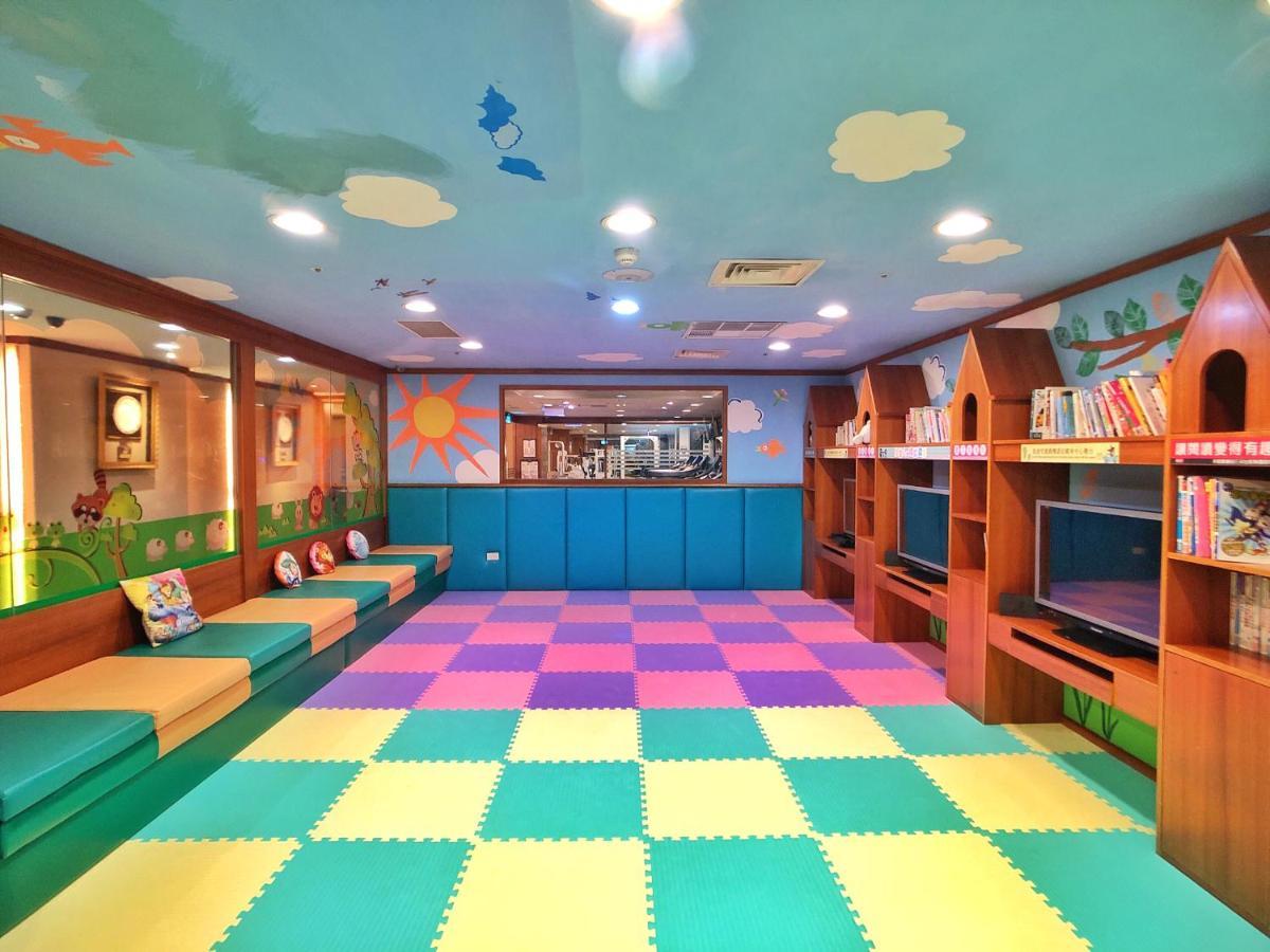 Evergreen Laurel Hotel - Taichung Esterno foto The photo shows a colorful children's playroom or reading area. The ceiling is painted blue with clouds, creating a cheerful atmosphere. On the floor, there is a soft, interlocking mat with alternating pastel colors, including pink, green, and yellow